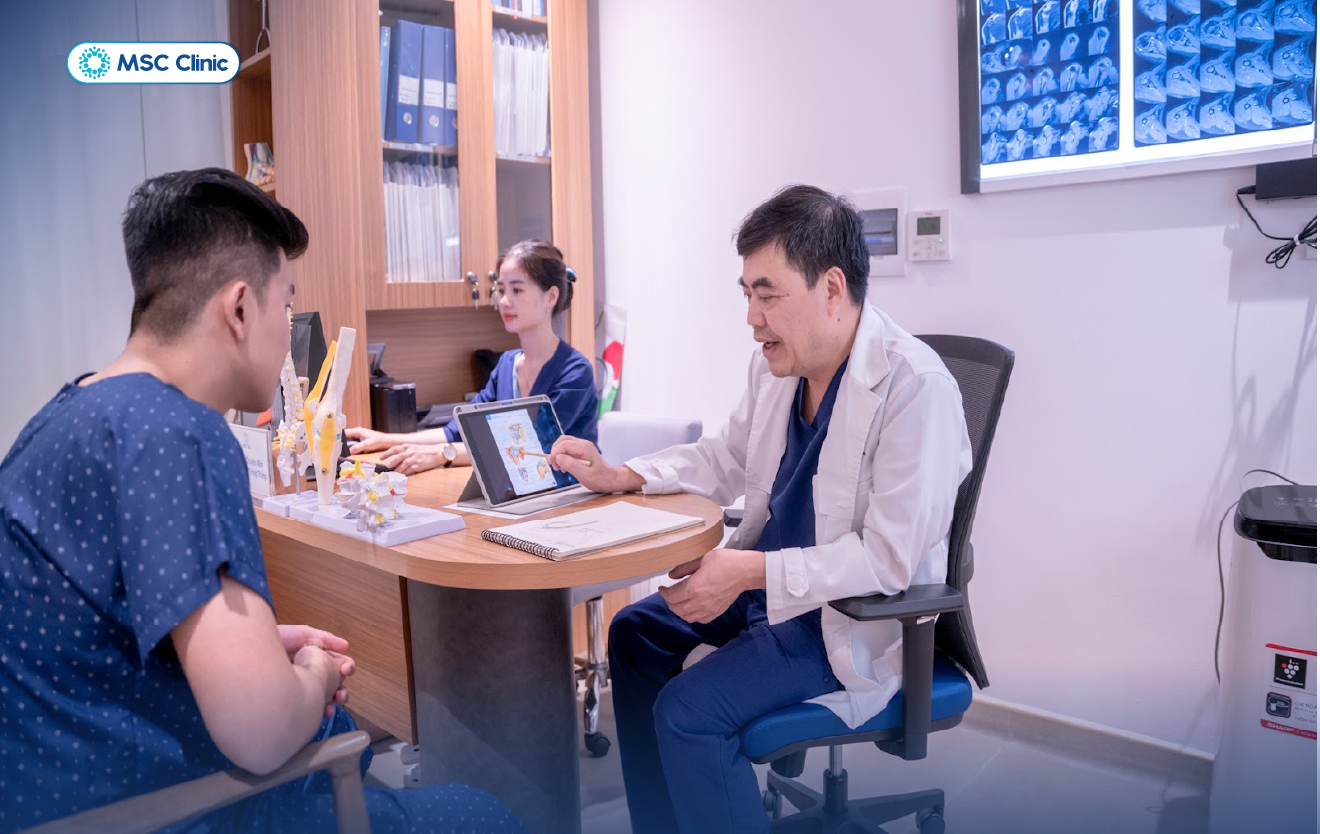 Hình ảnh bác sĩ Trần Trọng Thắng đang giải thích tình trạng tổn thương khớp vai cho bệnh nhân