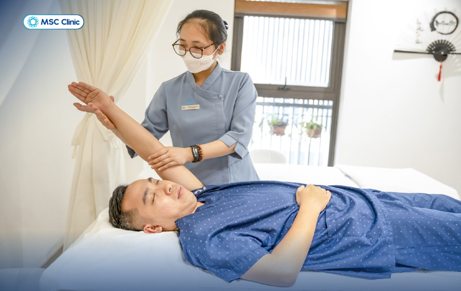 Kỹ thuật viên phục hồi chức năng trực tiếp hướng dẫn người bệnh tập luyện đúng kỹ thuật để cổ tay phục hồi an toàn và hiệu quả