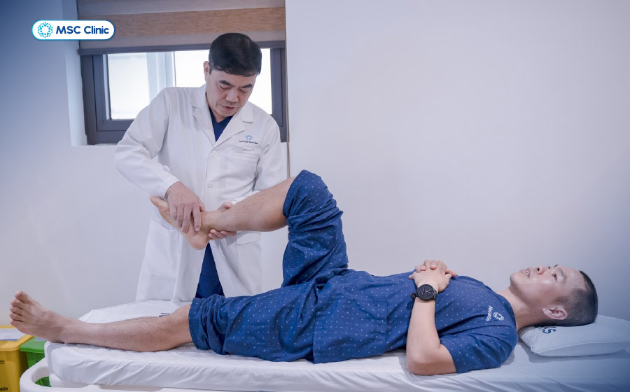 Bác sĩ Thắng thăm khám chấn thương cổ chân cho vận động viên Hùng Hải